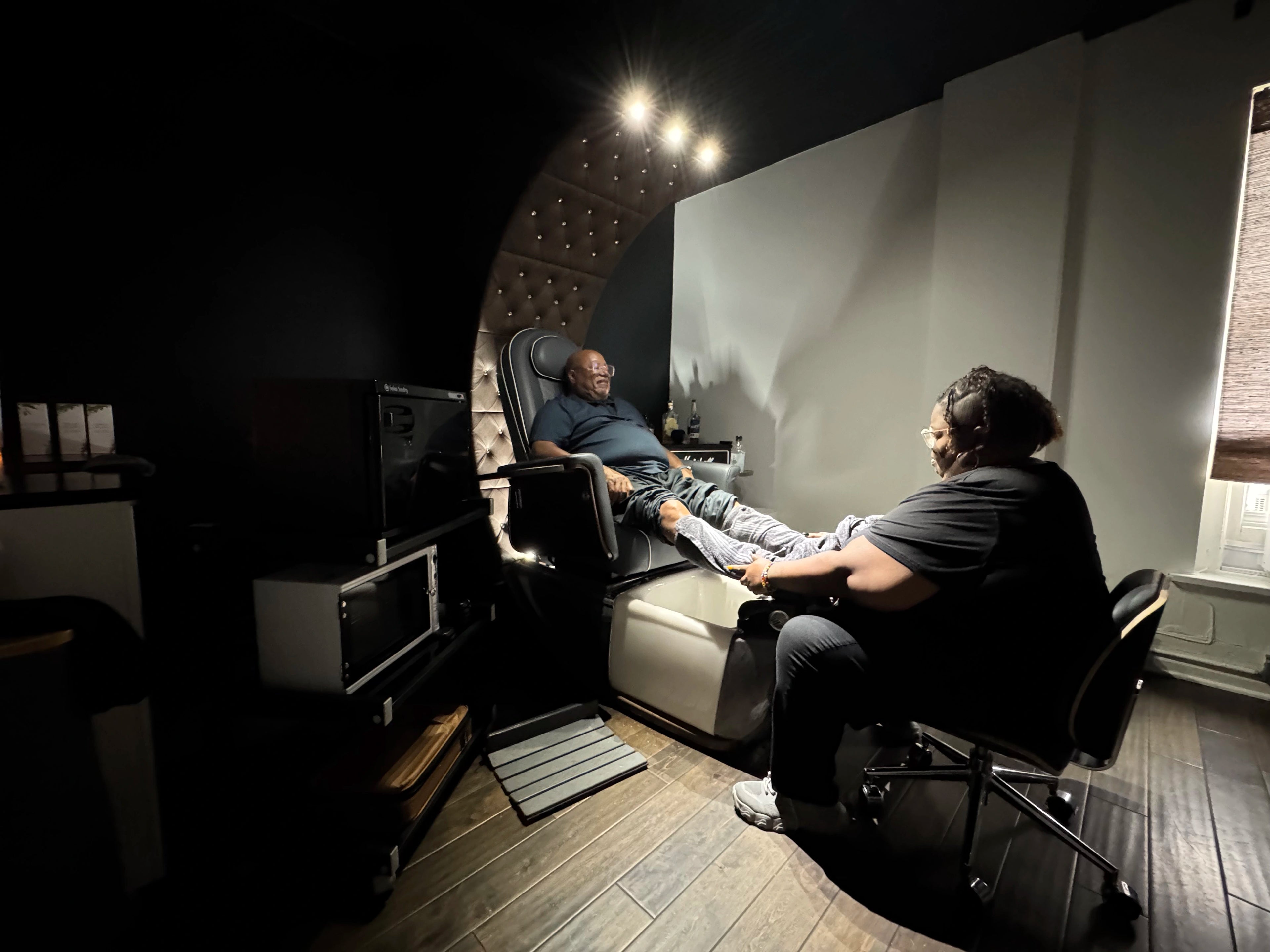 Two people in a room with soundproofing panels and audio equipment.